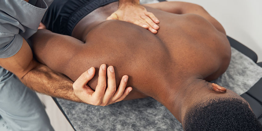 Delray Beach auto accident forms for chiropractor adjusting patient's shoulder to relieve pain